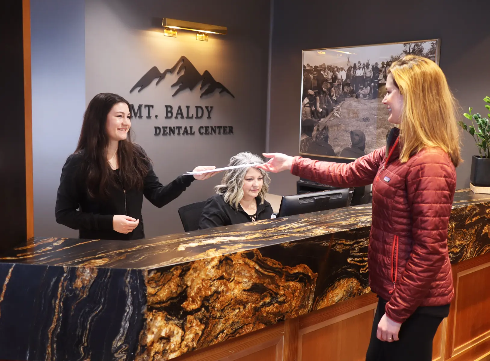 Dental assistant greeting new patient